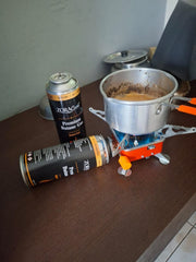 Real photo: ZORACook Portable Mini Gas Stove making chai, a 225g butane can screwed into the side port and a second can beside it